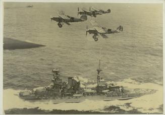 British battleship "HMS BARHAM" (1914) escorted by aircraft as it enters a harbour