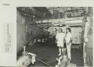 Crew member onboard "HMS BROADSWORD" (1976) showcasing the ship's helicopter hangar