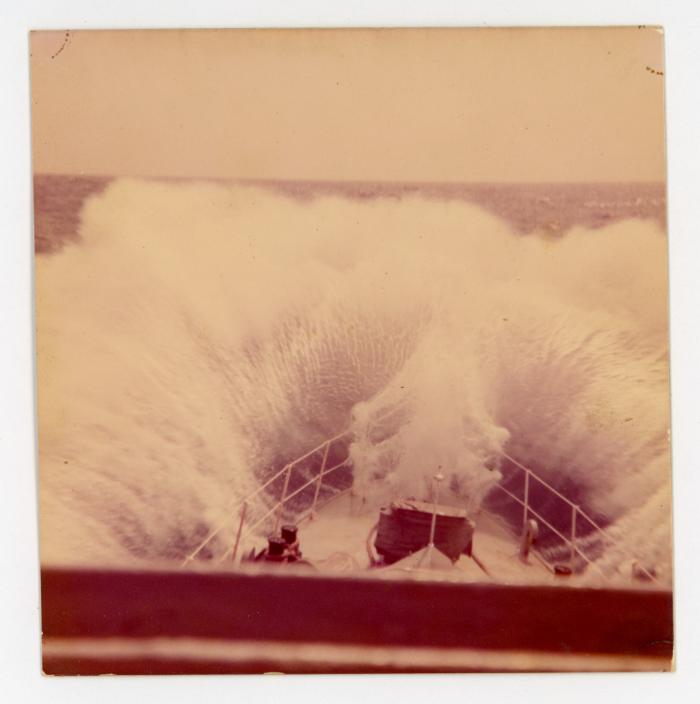 A ship hitting a wave while at sea