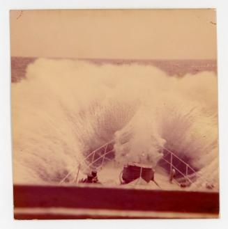A ship hitting a wave while at sea