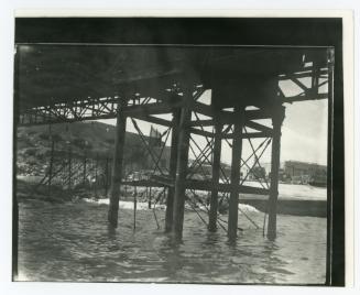 Metal piles rising out of the water forming the supports of Kalafrana pier