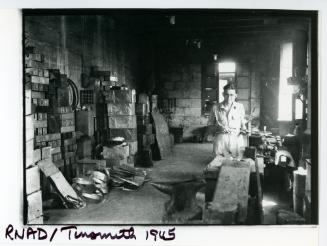A tinsmith working in a R.N.A.D. (Royal Naval Armaments Depot) workshop
