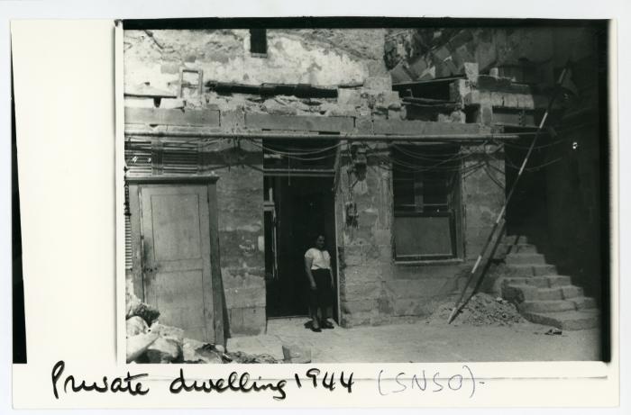 A young women standing on the threshold of a private dwelling
