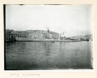 "HMS CLEOPATRA" docked in Parlatorio Wharf with the Dockyard E.V.T. Centre in the background