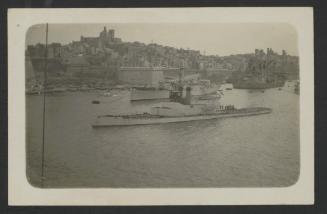 Surface warship in Grand Harbour, Malta, with Senglea, another surface vessel and a floating crane in the background