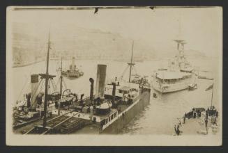View of a British battleship, merchant vessel and tug from another British surface warship in Grand Harbour, Malta