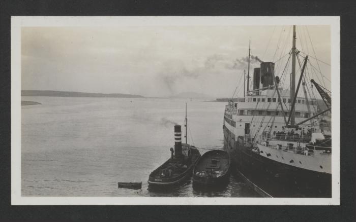 Harbour Tug? "Marine" next to a barge and a larger (Merchant?) Vessel in a foreign harbour